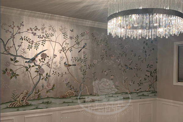Chinoiserie hand-painted wallpaper mural with birds, trees, and rocks on silver metallic leaf, installed in formal dining room