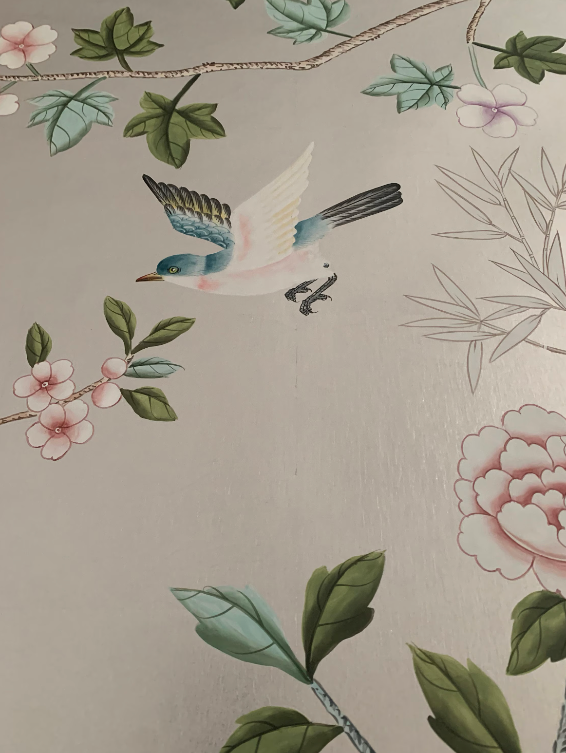 Chinoiserie hand-painted wallpaper mural with birds, trees, and rocks on silver metallic leaf, installed in formal dining room