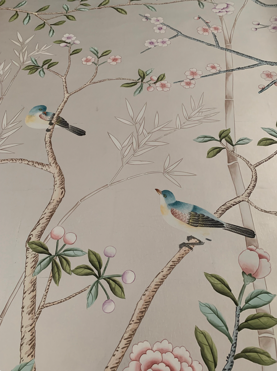 Chinoiserie hand-painted wallpaper mural with birds, trees, and rocks on silver metallic leaf, installed in formal dining room