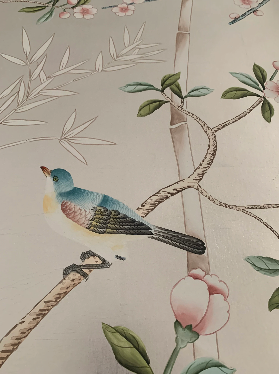 Chinoiserie hand-painted wallpaper mural with birds, trees, and rocks on silver metallic leaf, installed in formal dining room