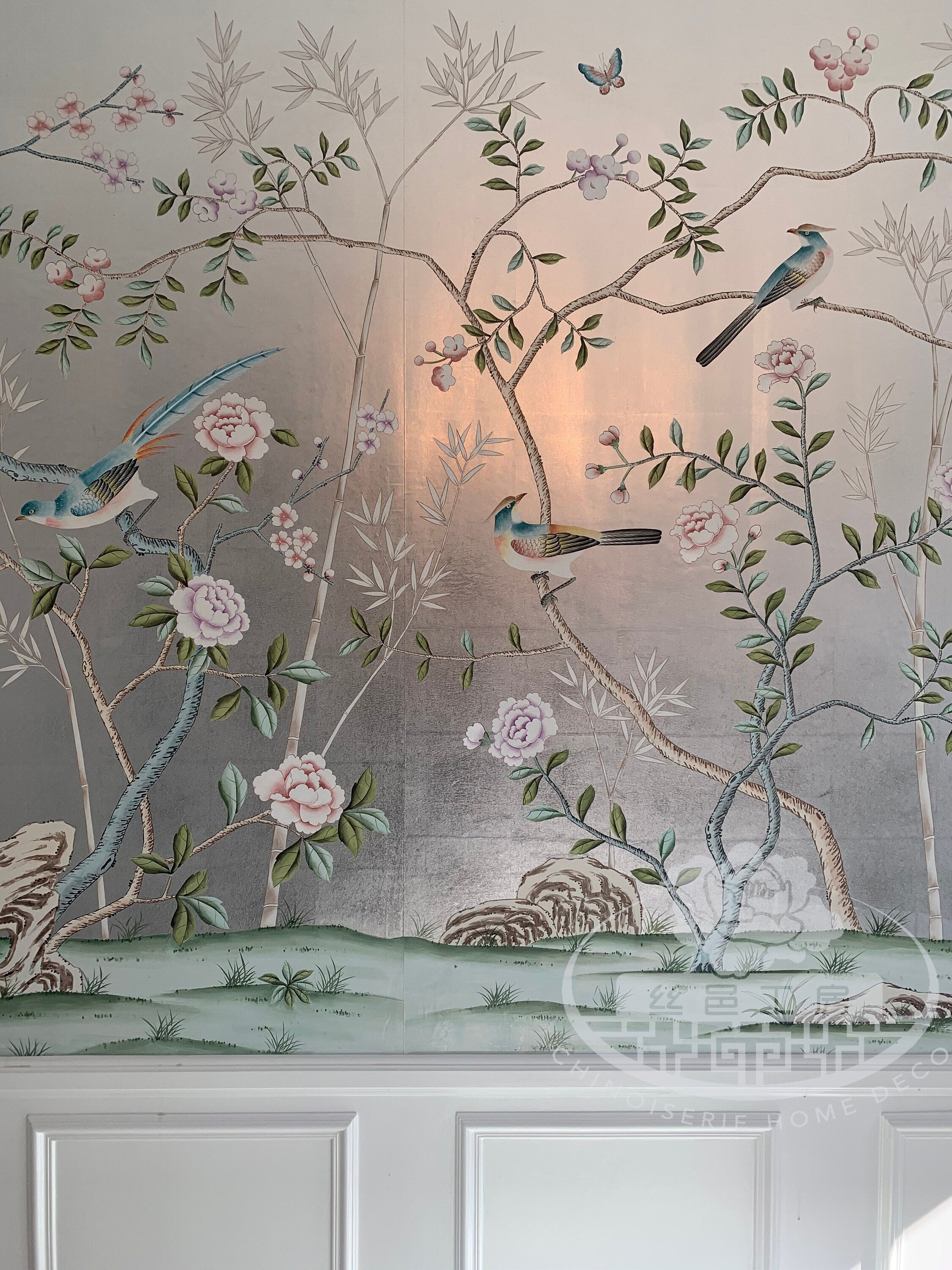 Chinoiserie hand-painted wallpaper mural with birds, trees, and rocks on silver metallic leaf, installed in formal dining room
