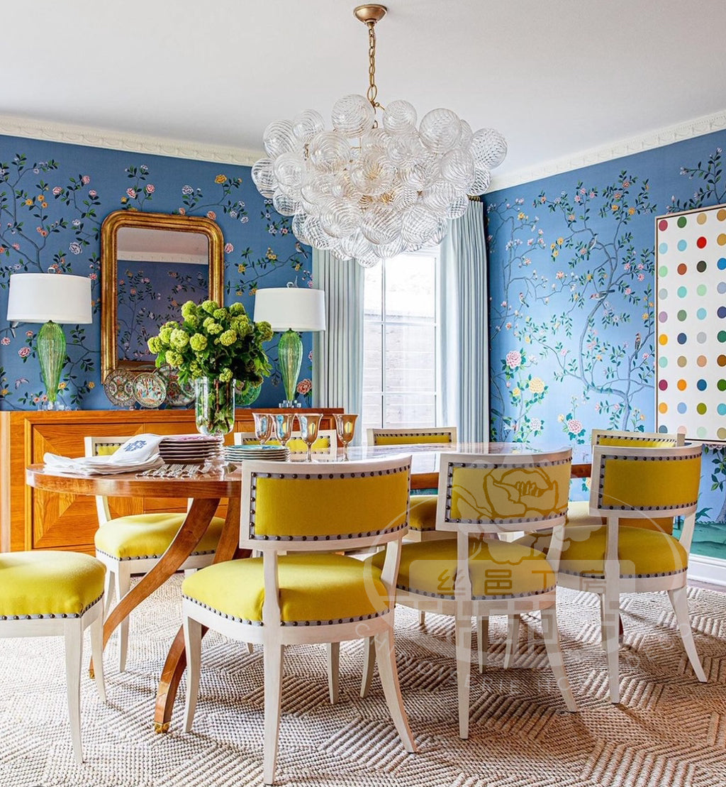 Chinoiserie mural on sky blue silk wallpaper with birds and flowers, hand-painted for a vibrant dining room interior with yellow chairs